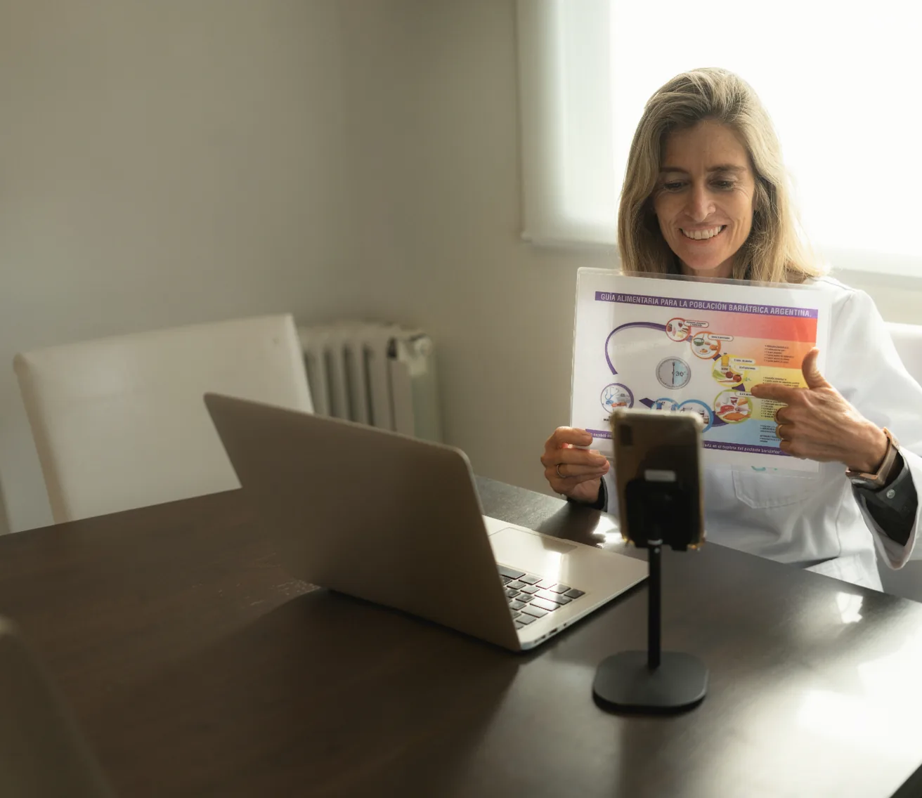 Médica mostrando un material educativo durante una videoconsulta