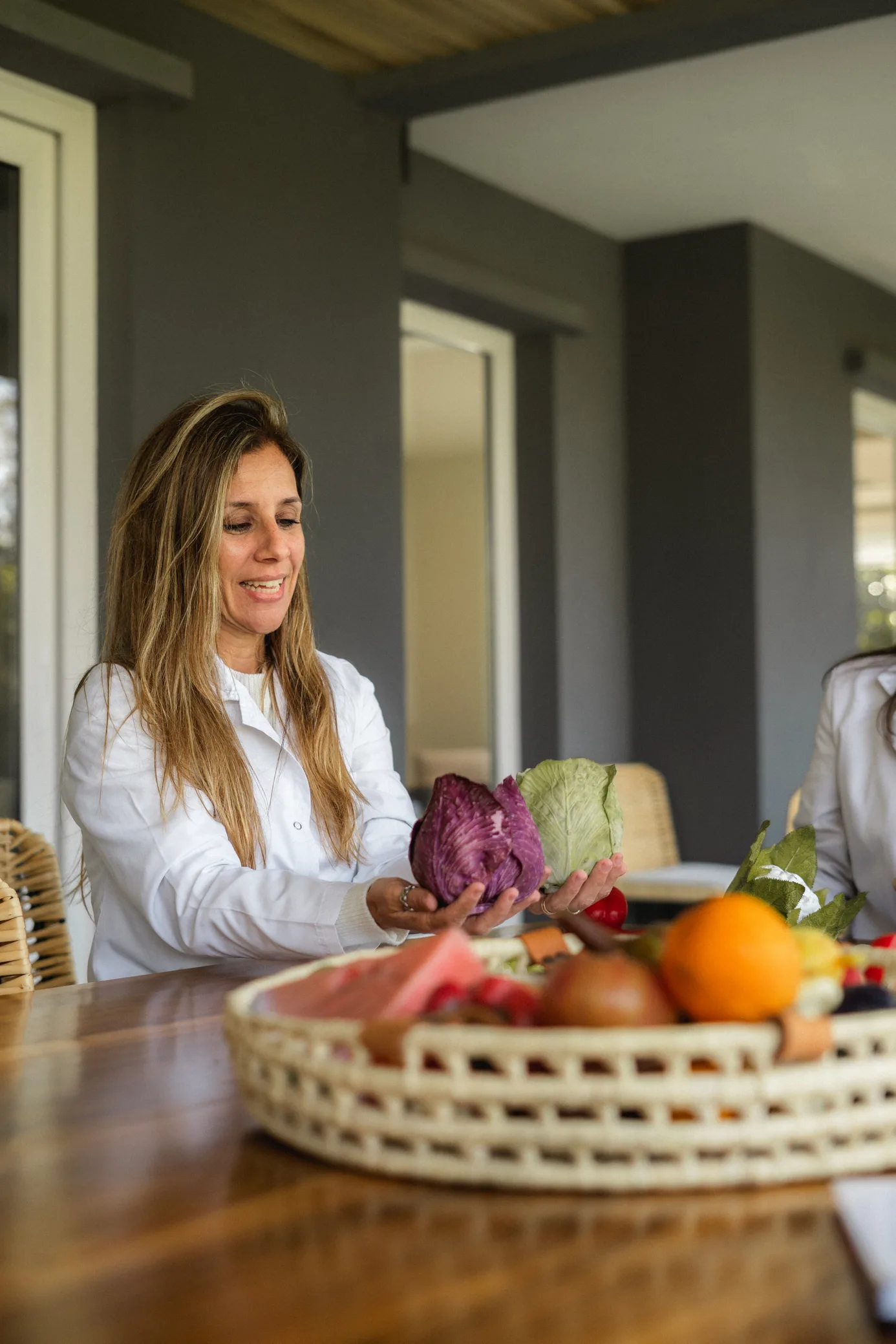 Mujer sonriendo mientras sostiene verduras frescas